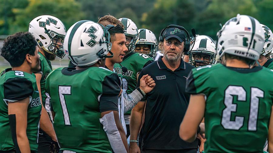 Football coaches talking to players during a game